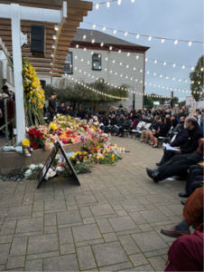People gathered on a patio, with flower arrangements.